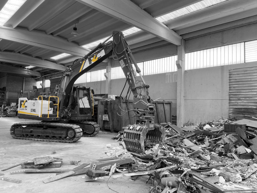 Edificio con ruspa e rifiuti derivanti da demolizione